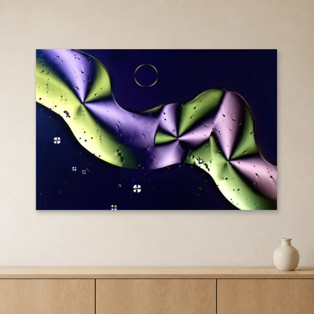 Sorbit als Mikrokristall-Wandbild auf Alu-Dibond: Grüne und violette Kristallformen an heller Wand über einem Sideboard aus Eichenholz (Raum-Mockup).