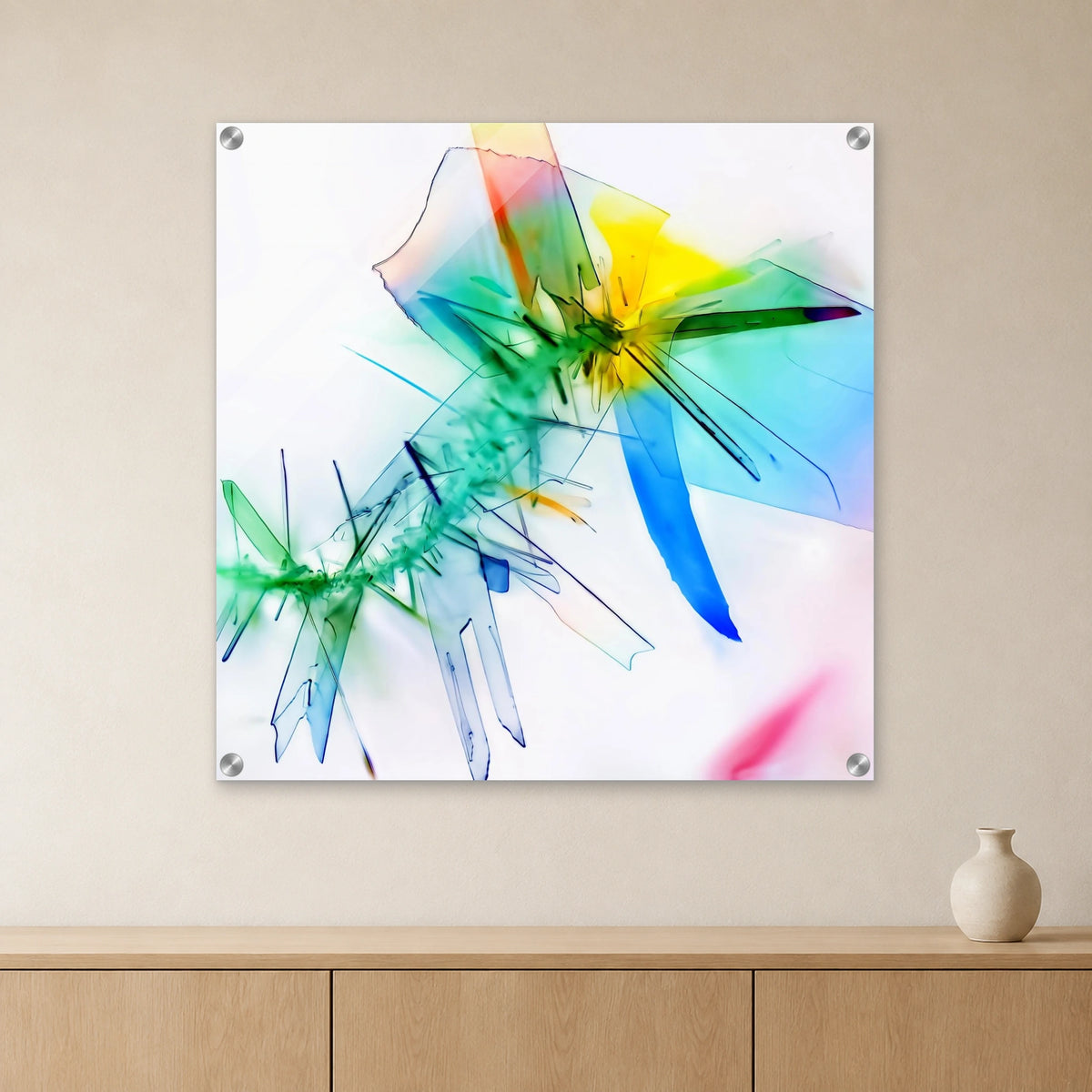 Benzoesäure als Mikrokristall-Wandbild auf Acrylglas – Motiv 1: Bunte, kantige Kristallformen auf hellem Grund an heller Wand über einem Sideboard aus Eichenholz (Raum-Mockup).