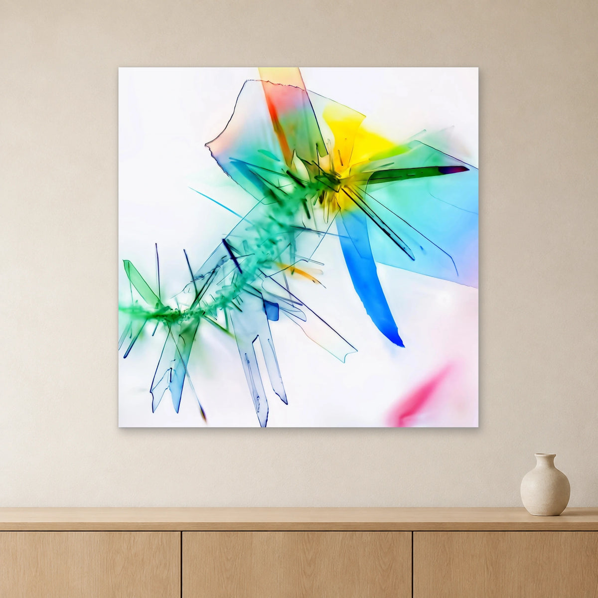 Benzoesäure als Mikrokristall-Wandbild auf Forex – Motiv 1: Bunte Kristallformen auf hellem Grund an heller Wand über einem Sideboard aus Eichenholz (Raum-Mockup).