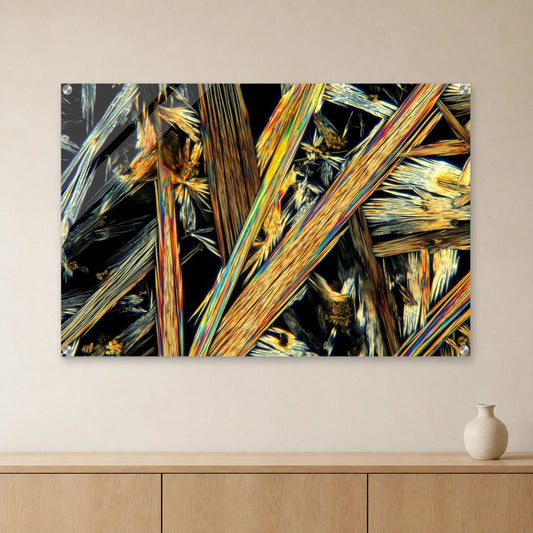 Koffein als Mikrokristall-Wandbild auf Acrylglas: Goldene und silbrige Kristallnadeln auf dunklem Grund an heller Wand über einem Sideboard aus Eichenholz (Raum-Mockup).