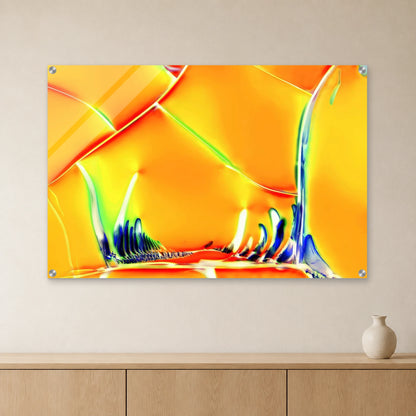 Optical Brightener als Mikrokristall-Wandbild auf Acrylglas – Motiv 2: Orange-gelbe Kristallstrukturen an heller Wand über einem Sideboard aus Eichenholz (Raum-Mockup).