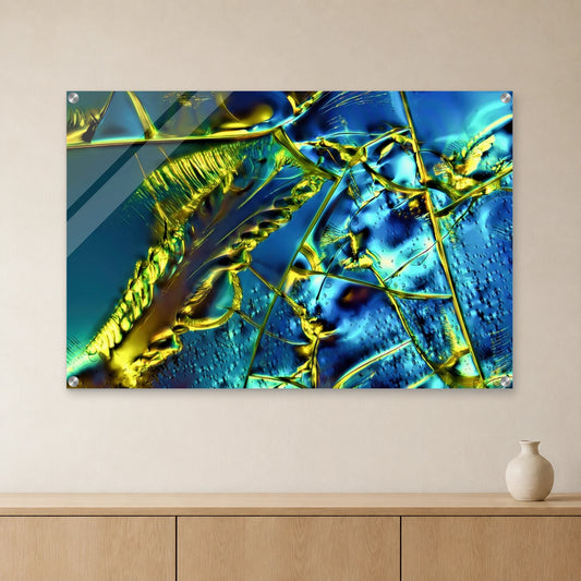 Optical Brightener als Mikrokristall-Wandbild auf Acrylglas – Motiv 1: Türkise und goldgelbe Kristallstrukturen an heller Wand über einem Sideboard aus Eichenholz (Raum-Mockup).