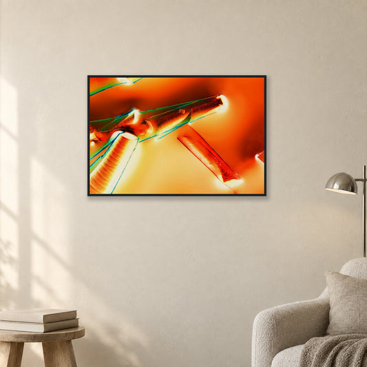 Alaun mit Öl als Mikrokristall-Poster mit Holzrahmen – Motiv 2: Orange und rote Kristallformen in schwarzem Holzrahmen an einer hellen Wand neben einer Leseecke (Raum-Mockup).