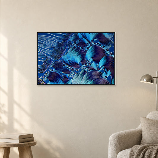 Brodacid als Mikrokristall-Poster mit Holzrahmen: Blaue, fächerartige Kristallstrukturen in schwarzem Holzrahmen an einer hellen Wand neben einer Leseecke (Raum-Mockup).