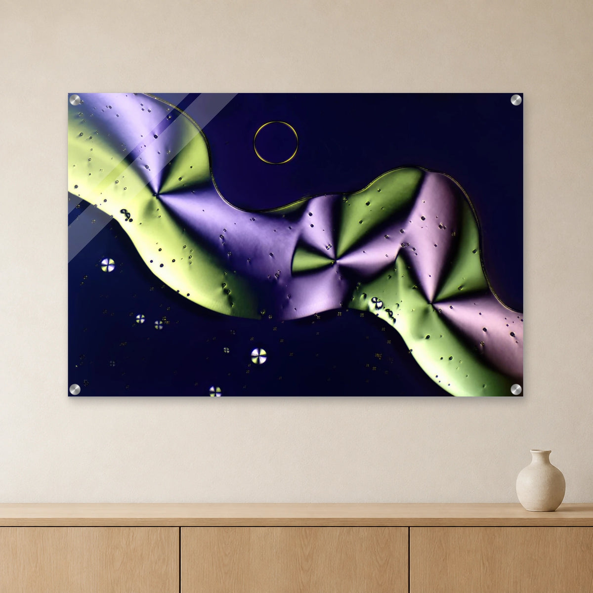 Sorbit als Mikrokristall-Wandbild auf Acrylglas: Grüne und violette Kristallformen auf dunklem Grund an heller Wand über einem Sideboard aus Eichenholz (Raum-Mockup).